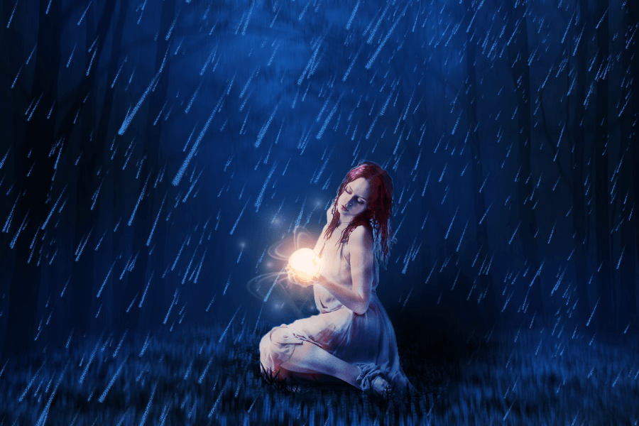 After: a woman sitting in grass while in rains holding a ball of light.