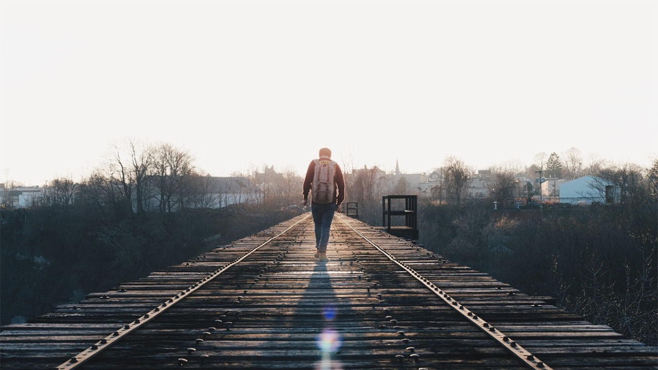 Before: A man walking down train tracks